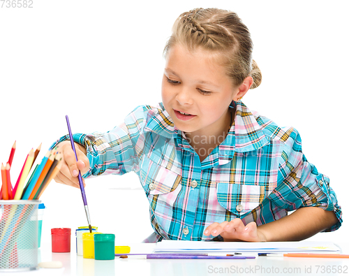 Image of Little girl is painting with gouache