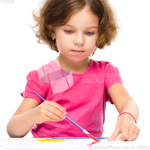 Image of Little girl is painting with gouache