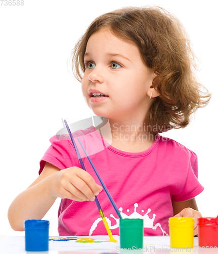 Image of Little girl is painting with gouache