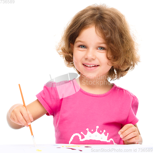 Image of Little girl is painting with gouache