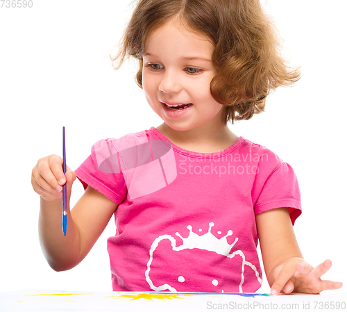 Image of Little girl is painting with gouache