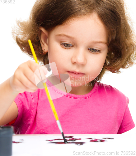 Image of Little girl is painting with gouache