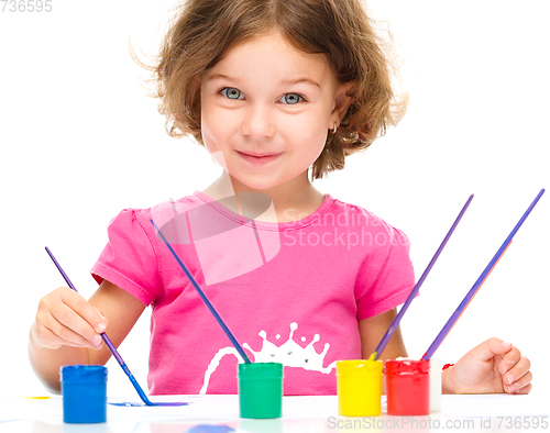 Image of Little girl is painting with gouache