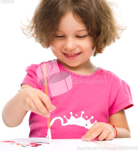 Image of Little girl is painting with gouache