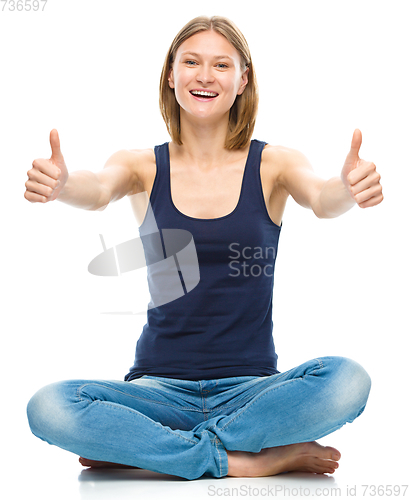 Image of Young happy woman is showing thumb up sign