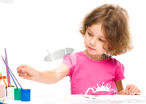 Image of Little girl is painting with gouache