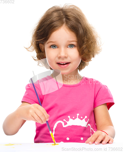 Image of Little girl is painting with gouache