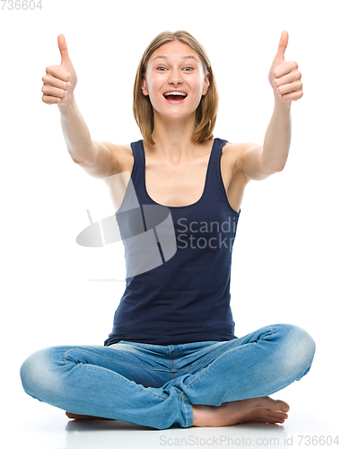 Image of Young happy woman is showing thumb up sign