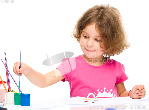 Image of Little girl is painting with gouache