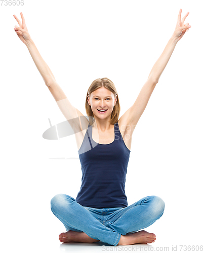 Image of Young woman is raised her hands up in joy