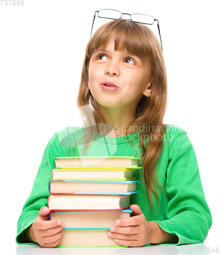 Image of Young girl is daydreaming while reading book