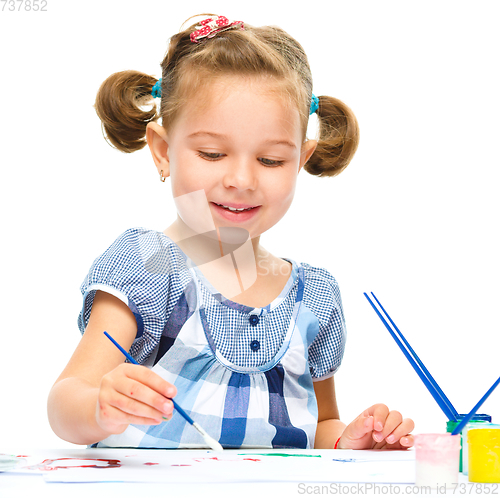 Image of Little girl is painting with gouache