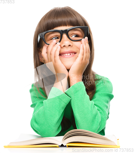 Image of Young girl is daydreaming while reading book