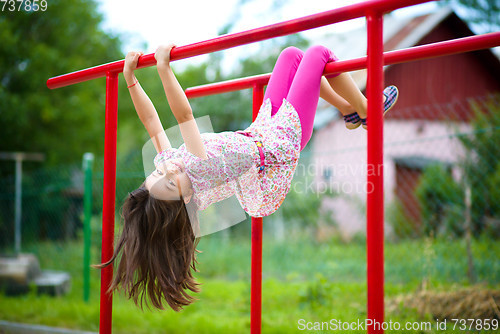 Image of Cute little girl is playing in playground