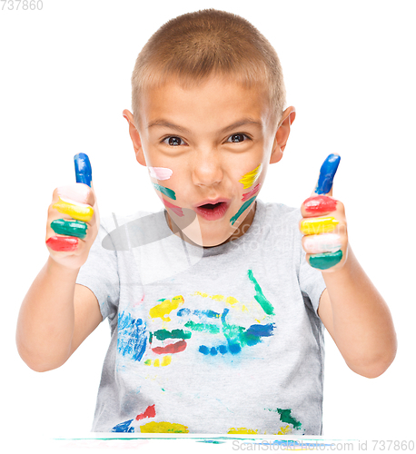 Image of Portrait of a cute boy playing with paints