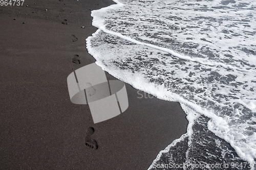 Image of foot prints on black sand