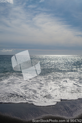 Image of ocean water on black sand