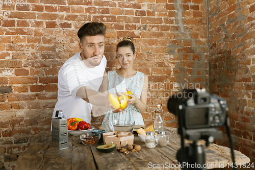 Image of Young couple cooking and recording live video for vlog and social media