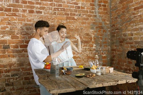 Image of Young couple cooking and recording live video for vlog and social media