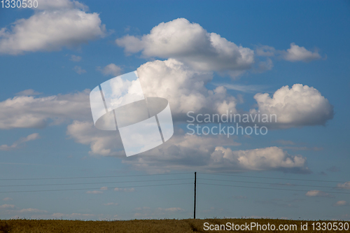 Image of Landscape with field and cloudy blue sky.