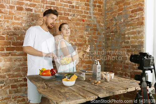 Image of Young couple cooking and recording live video for vlog and social media