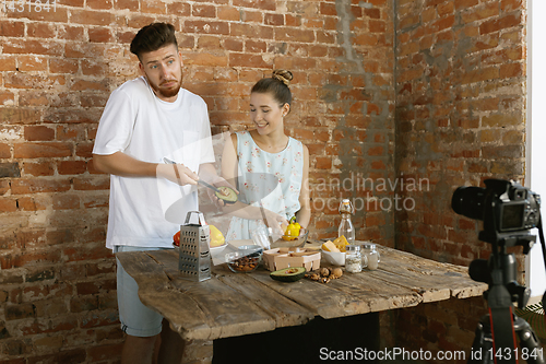 Image of Young couple cooking and recording live video for vlog and social media