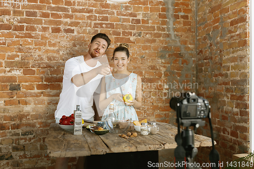 Image of Young couple cooking and recording live video for vlog and social media