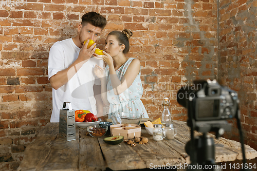 Image of Young couple cooking and recording live video for vlog and social media