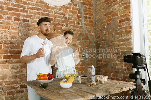 Image of Young couple cooking and recording live video for vlog and social media