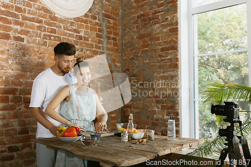 Image of Young couple cooking and recording live video for vlog and social media