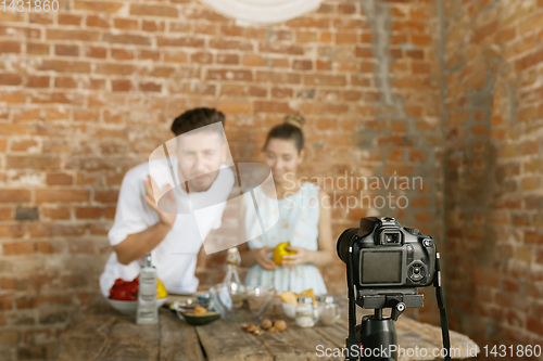 Image of Young couple cooking and recording live video for vlog and social media