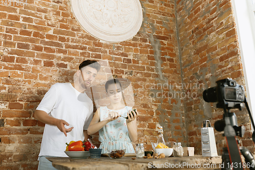 Image of Young couple cooking and recording live video for vlog and social media
