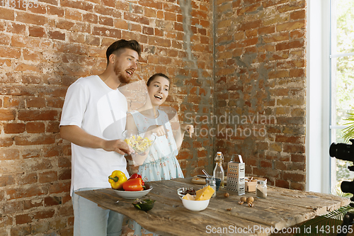 Image of Young couple cooking and recording live video for vlog and social media