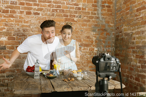 Image of Young couple cooking and recording live video for vlog and social media