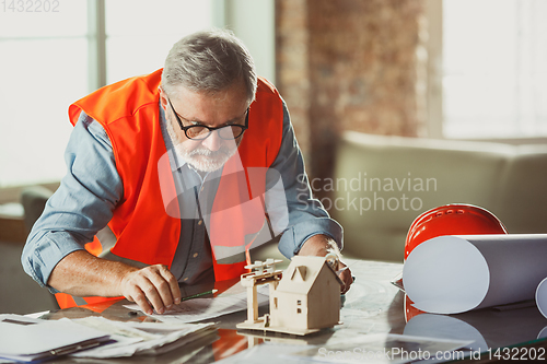 Image of Close up of male architect-engineer making a model of house