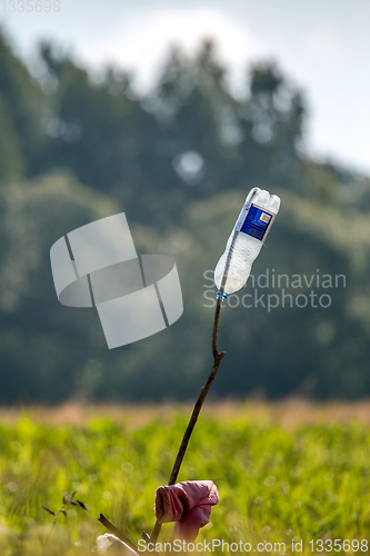 Image of Plastic bottle in green field.