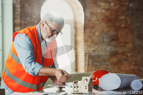 Image of Close up of male architect-engineer making a model of house