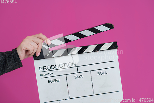 Image of movie clapper on pink background