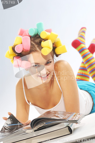 Image of A woman with hair curlers and magazines