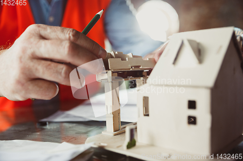 Image of Close up of male architect-engineer making a model of house