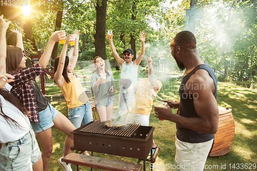 Image of Happy friends are having beer and barbecue party at sunny day