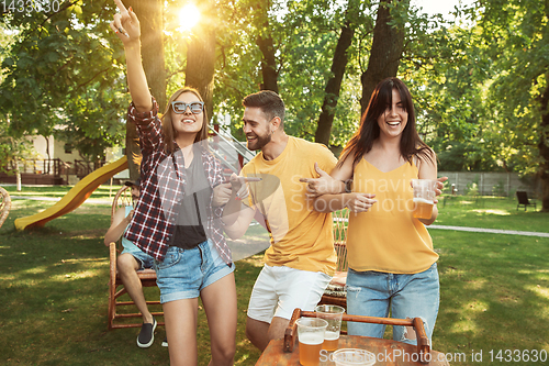 Image of Happy friends are having beer and barbecue party at sunny day