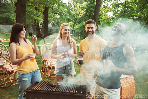 Image of Happy friends are having beer and barbecue party at sunny day