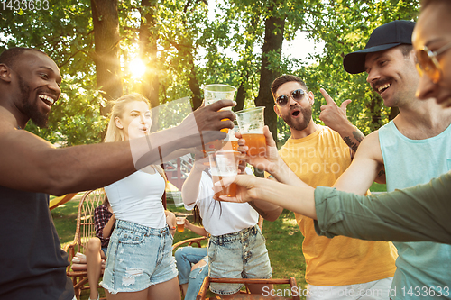 Image of Happy friends are having beer and barbecue party at sunny day
