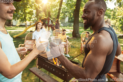 Image of Happy friends are having beer and barbecue party at sunny day