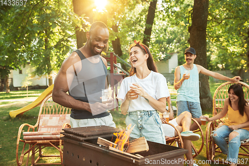 Image of Happy friends are having beer and barbecue party at sunny day