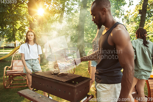 Image of Happy friends are having beer and barbecue party at sunny day