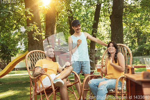 Image of Happy friends are having beer and barbecue party at sunny day