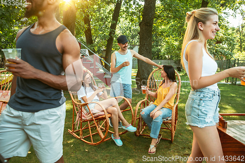 Image of Happy friends are having beer and barbecue party at sunny day