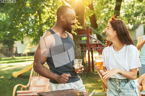 Image of Happy friends are having beer and barbecue party at sunny day